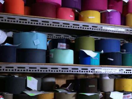 Shelves of colored ribbons and trims on rolls.