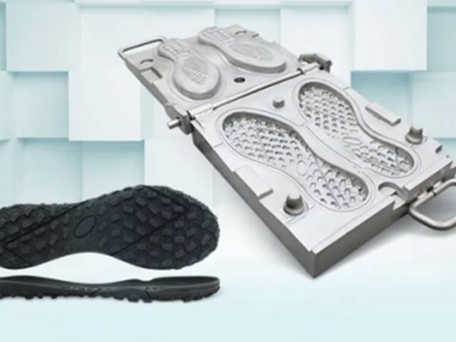 A steel outsole mold with a black rubber outsole beside it.