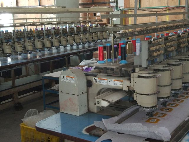 At one of our partner factories: a multi-head embroidery machine with spools of thread.